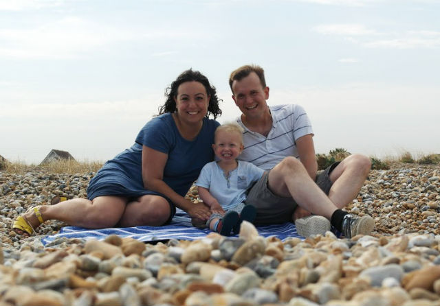 Me, John and Max sat on blanket on pebble beach with blue skies