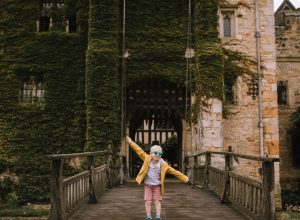 Little boy dressed in yellow raincoat, posing on the drawbridge at Hever Castle